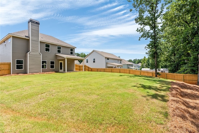 750 Mcdonald Dr, Opelika, AL 36801 - rear view of house with a fenced backyard, a chimney, and roof with shingles