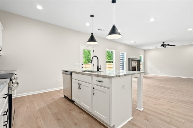 750 Mcdonald Dr, Opelika, AL 36801 - kitchen featuring stainless steel appliances, light wood finished floors, ceiling fan, a center island with sink, and a kitchen breakfast bar