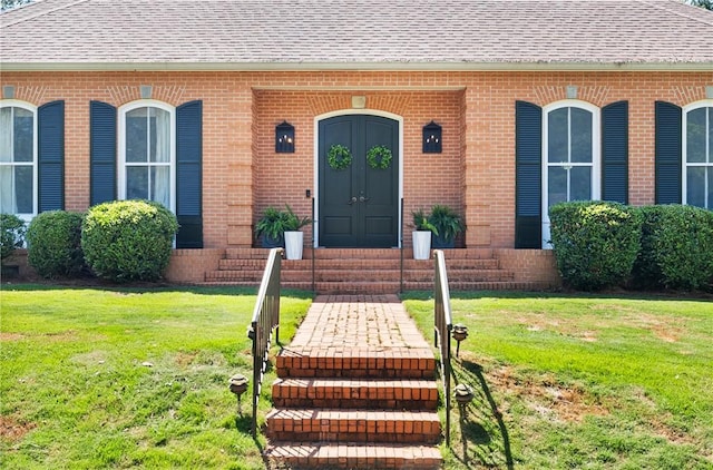 613 5th Ave, Opelika, AL 36801 - view of exterior entry featuring a shingled roof, brick siding, and a lawn