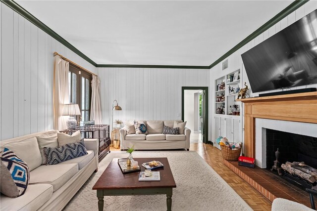 613 5th Ave, Opelika, AL 36801 - living room with ornamental molding, healthy amount of natural light, a brick fireplace, built in shelves, and wooden walls
