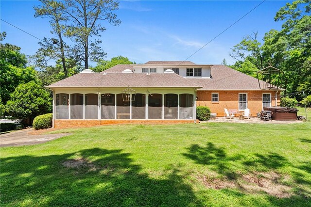 613 5th Ave, Opelika, AL 36801 - rear view of house with a hot tub, a sunroom, and a lawn
