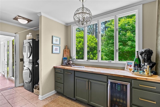 613 5th Ave, Opelika, AL 36801 - laundry room with beverage cooler, stacked washer / dryer, healthy amount of natural light, baseboards, and crown molding
