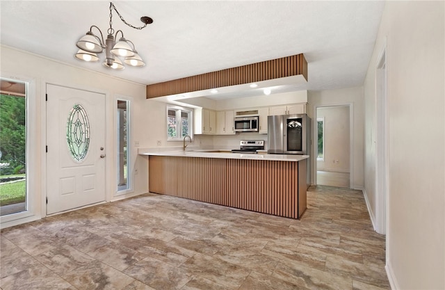 158 Alice Cir, Auburn, AL 36830 - kitchen featuring stainless steel appliances, a peninsula, a chandelier, light countertops, and decorative light fixtures