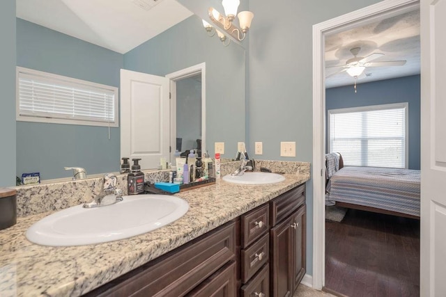 ensuite bathroom with double vanity, wood finished floors, a sink, and ensuite bathroom