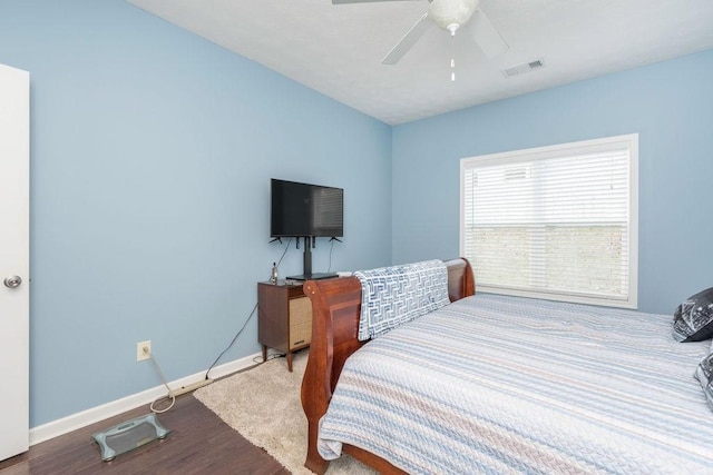 bedroom featuring visible vents, ceiling fan, baseboards, and wood finished floors