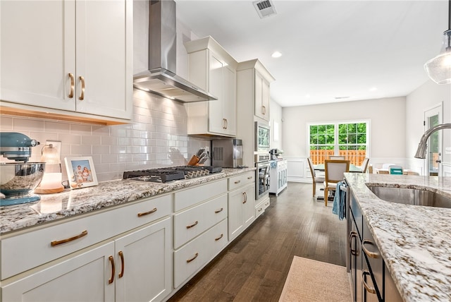 1803 Solamere Ct, Auburn, AL 36832 - kitchen with wall chimney exhaust hood, a sink, appliances with stainless steel finishes, dark wood-style floors, and light stone counters