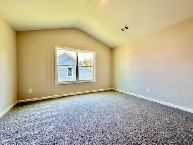 empty room featuring carpet floors and vaulted ceiling