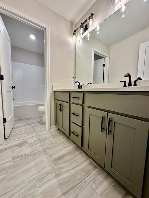 full bathroom with shower / bathing tub combination, vanity, and toilet