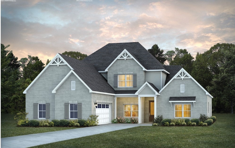 craftsman inspired home featuring a garage and a lawn