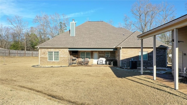 rear view of house featuring a yard, central AC, and a patio area