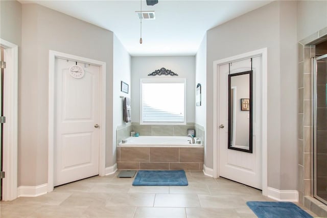 bathroom featuring tile patterned flooring and shower with separate bathtub