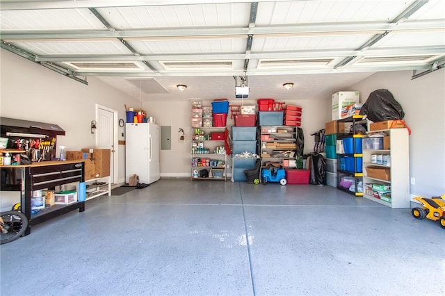 garage featuring electric panel and white fridge