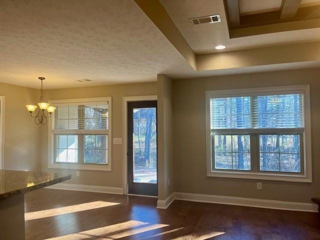 doorway to outside featuring dark wood-style floors, a chandelier, visible vents, and baseboards