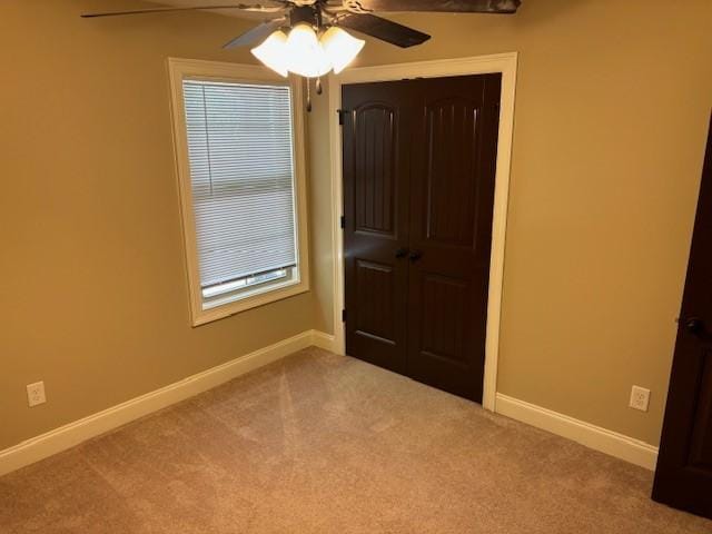 unfurnished bedroom featuring a ceiling fan, carpet flooring, and baseboards