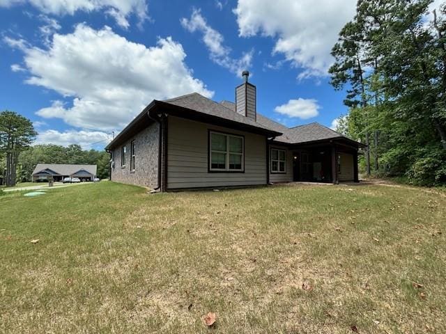 back of property with a lawn and a chimney