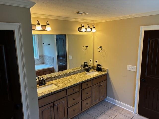 bathroom with crown molding, visible vents, a sink, and tile patterned floors