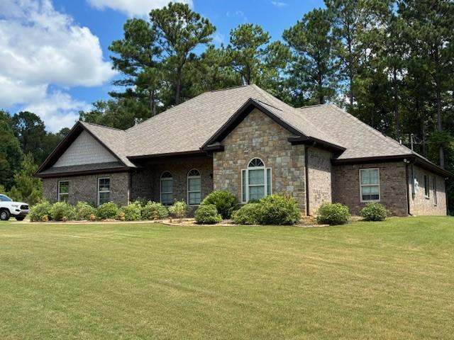 view of front of property with a front lawn and a shingled roof