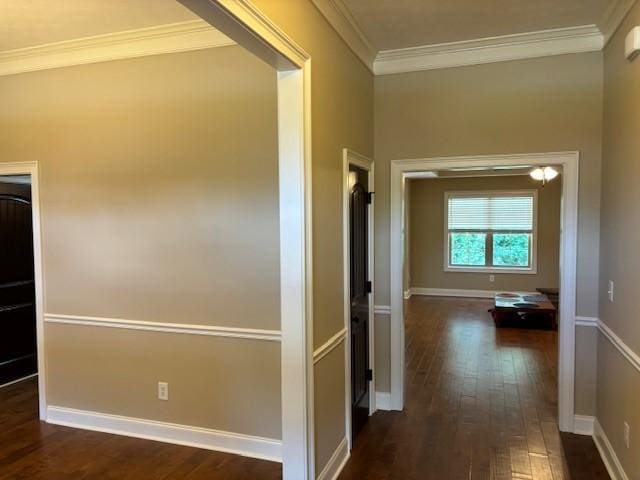 hall with dark wood-style floors, baseboards, and crown molding