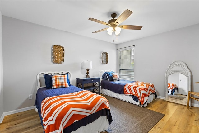 bedroom featuring baseboards, ceiling fan, and wood finished floors