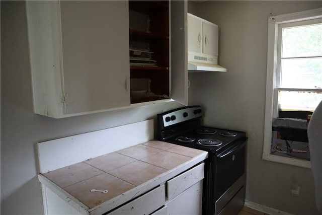 kitchen featuring electric range oven, under cabinet range hood, tile countertops, white cabinets, and open shelves