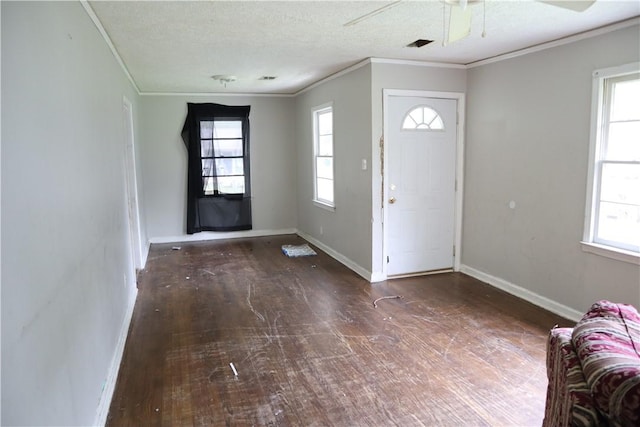 entrance foyer with ornamental molding, hardwood / wood-style floors, a ceiling fan, and baseboards