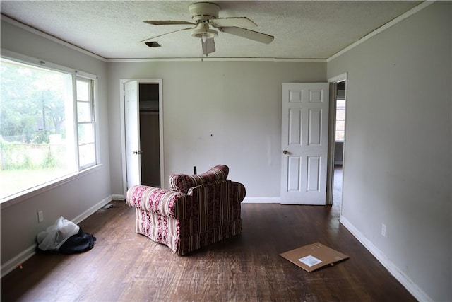 sitting room featuring ceiling fan, wood finished floors, ornamental molding, a textured ceiling, and baseboards