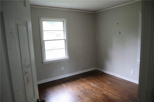 empty room with dark wood-style floors, plenty of natural light, ornamental molding, and baseboards