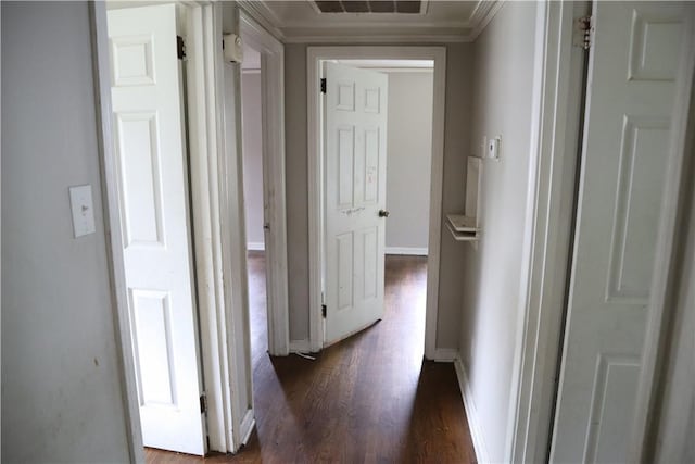 hallway featuring dark wood-type flooring, baseboards, and ornamental molding