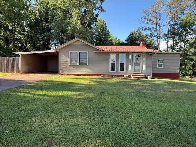 ranch-style house featuring driveway, a carport, metal roof, a chimney, and entry steps