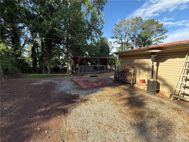 view of property exterior with a patio and an outdoor fire pit