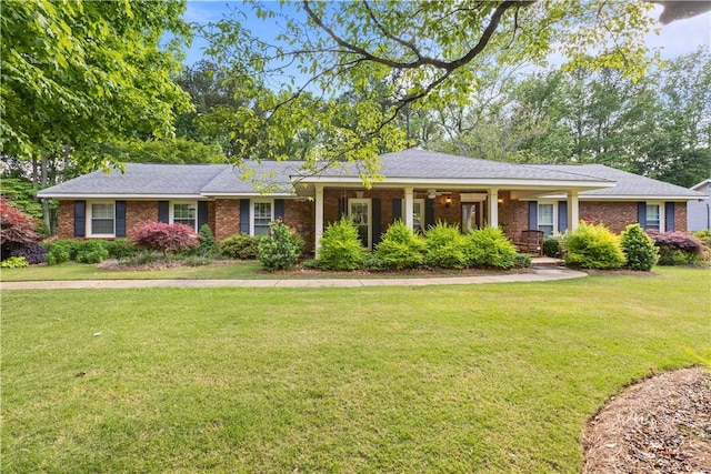 ranch-style home featuring a front yard, covered porch, and brick siding