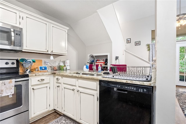 1041 Stonegate Dr Unit C, Auburn, AL 36830 - kitchen with appliances with stainless steel finishes, a sink, white cabinets, vaulted ceiling, and wood finished floors