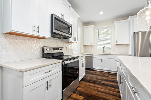 854 Village Dr, Opelika, AL 36801 - kitchen featuring appliances with stainless steel finishes, white cabinets, light countertops, dark wood-style flooring, and recessed lighting