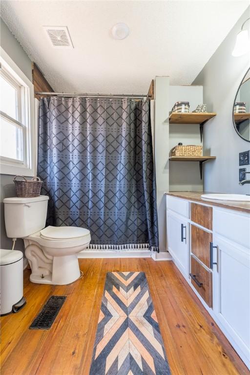 bathroom featuring vanity, hardwood / wood-style floors, toilet, and a shower with shower curtain