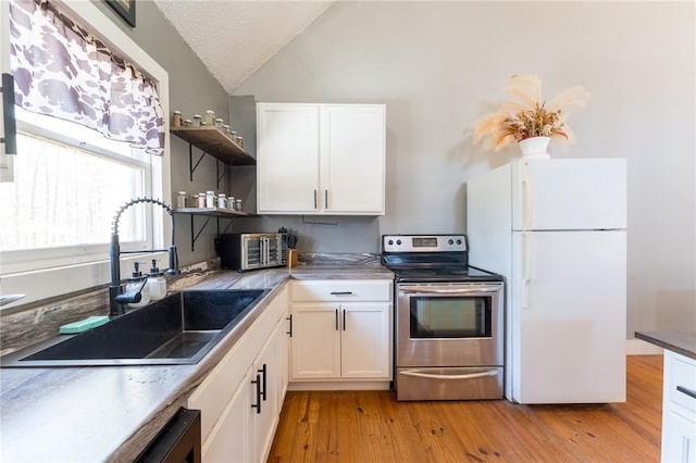 kitchen featuring vaulted ceiling, sink, white cabinets, white fridge, and electric range