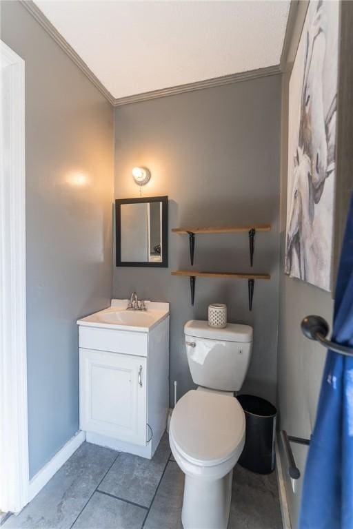 bathroom with tile patterned flooring, vanity, crown molding, and toilet