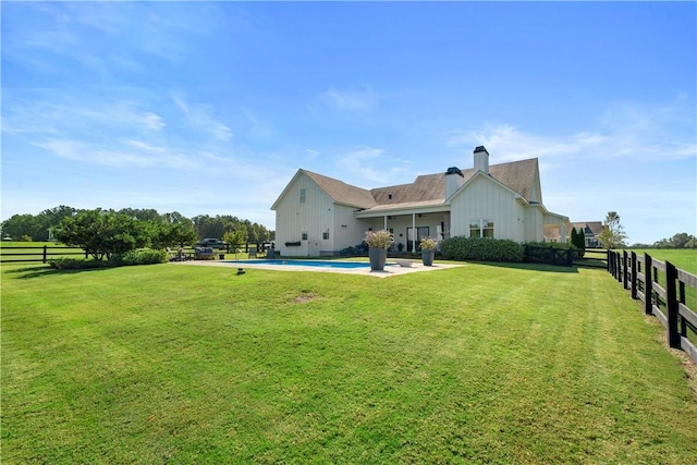 back of house featuring a lawn, a patio area, and a fenced in pool