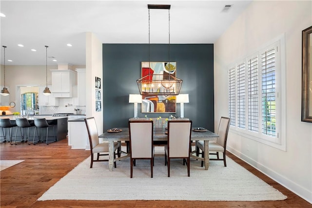 dining room featuring hardwood / wood-style flooring and an inviting chandelier