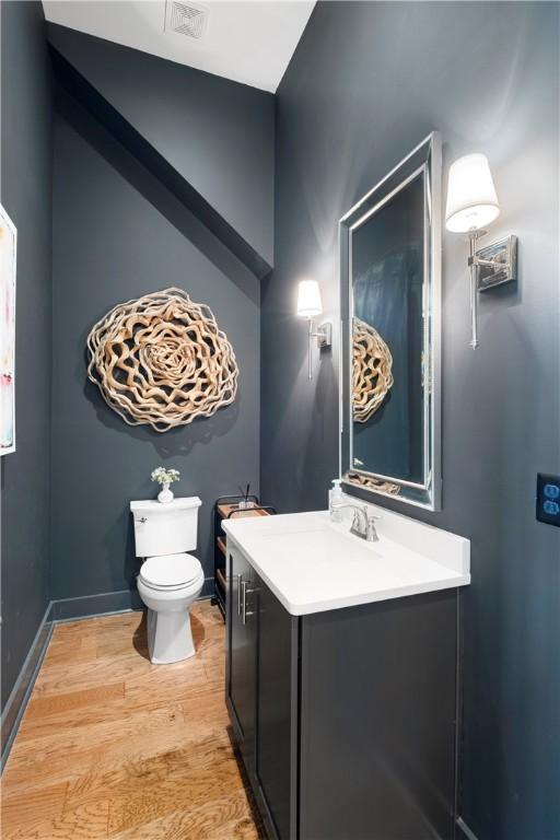 bathroom with hardwood / wood-style floors, vanity, and toilet