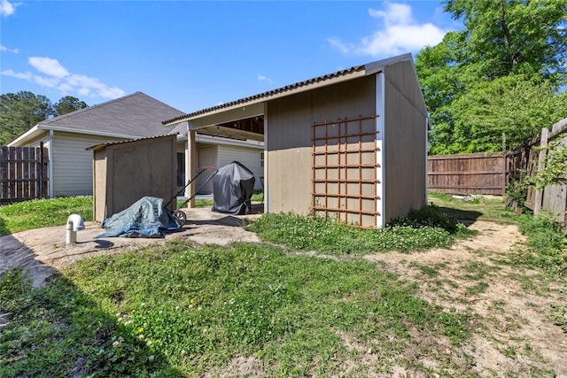 back of house with an outbuilding and a fenced backyard