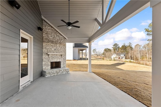 view of patio featuring ceiling fan and an outdoor stone fireplace