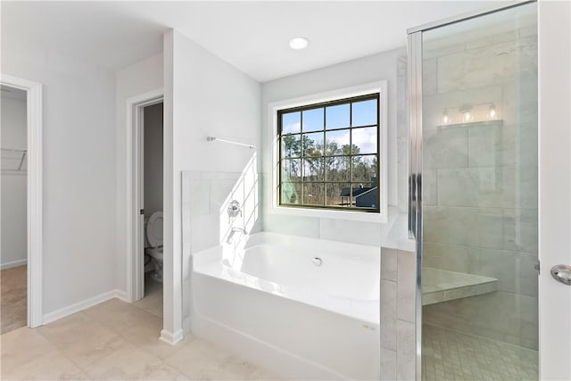 bathroom featuring toilet and independent shower and bath