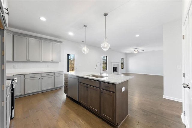 kitchen featuring stainless steel appliances, sink, pendant lighting, an island with sink, and dark hardwood / wood-style floors