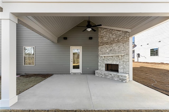 view of patio / terrace featuring ceiling fan and an outdoor stone fireplace