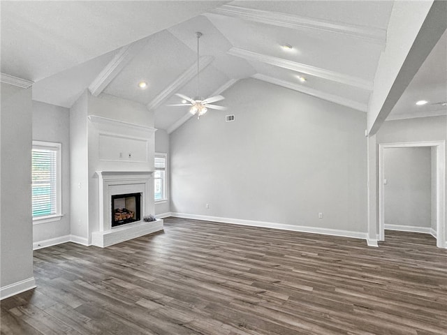 unfurnished living room with a healthy amount of sunlight, lofted ceiling with beams, ceiling fan, and dark wood-type flooring