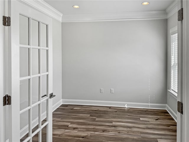 empty room with dark hardwood / wood-style flooring and crown molding