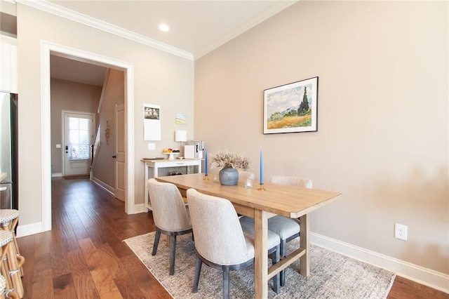 dining space featuring dark wood-type flooring and ornamental molding