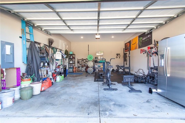 garage with stainless steel fridge with ice dispenser, electric panel, and a garage door opener