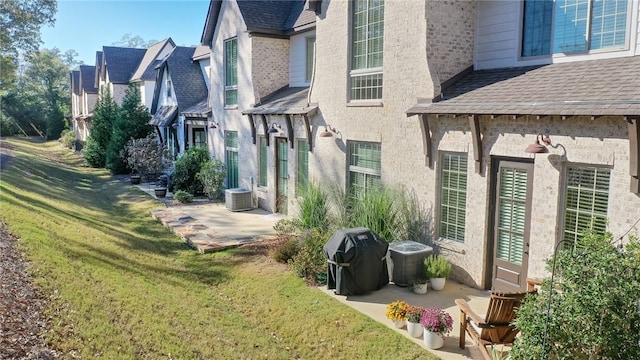 view of side of property featuring central AC and a yard