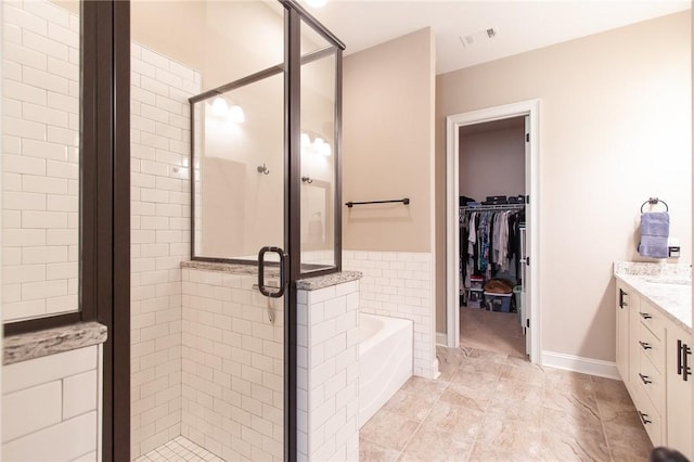 bathroom featuring vanity and independent shower and bath